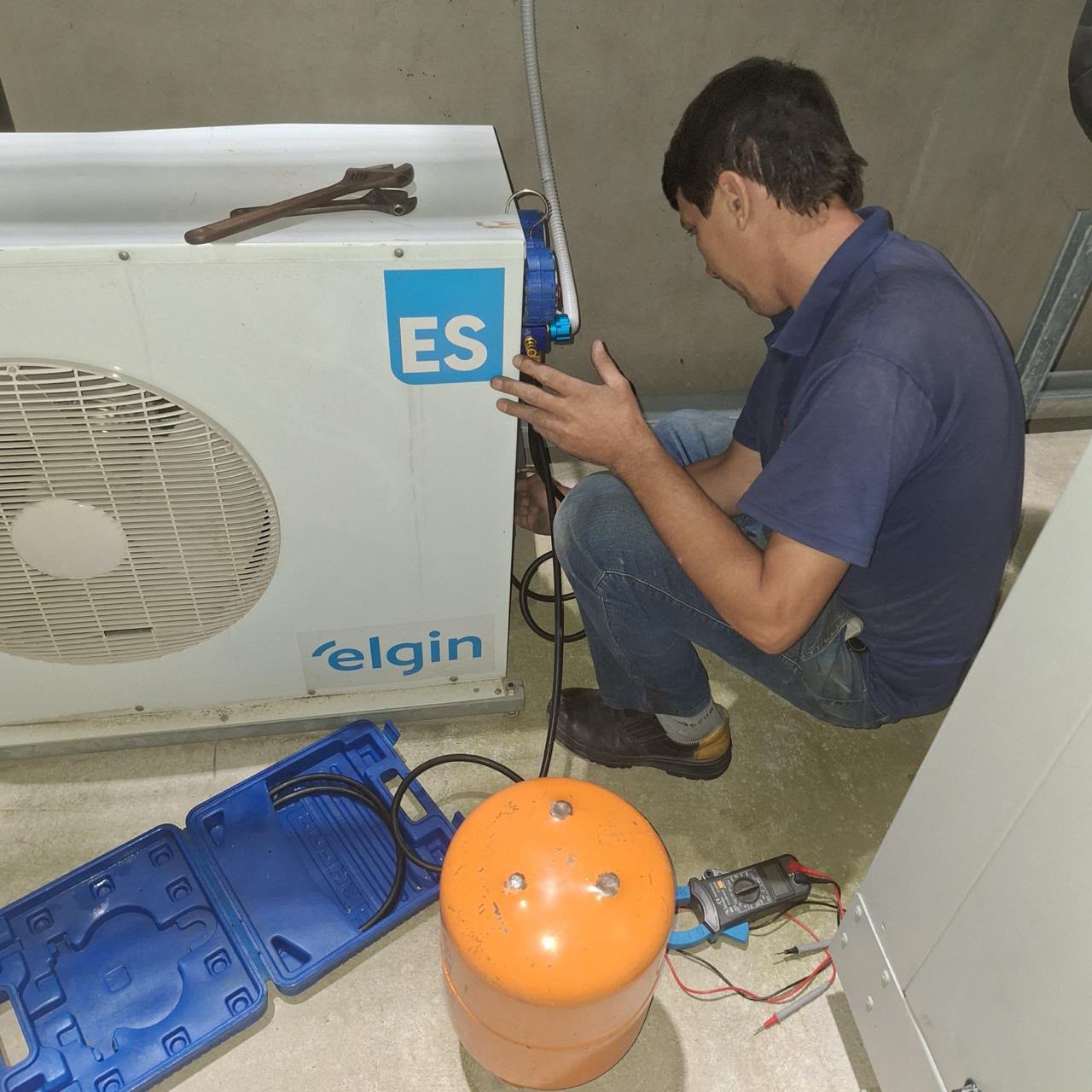 Técnico realizando manutenção em condensadora Elgin
